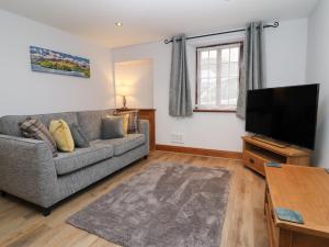 a living room with a couch and a flat screen tv at Fryston Cottage in Keswick