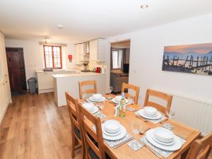 a dining room with a table and chairs and a kitchen at Fryston Cottage in Keswick +11 photos