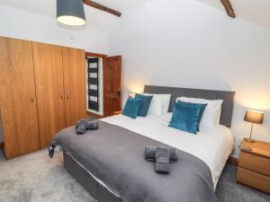 a bedroom with a large bed with blue pillows at Fryston Cottage in Keswick