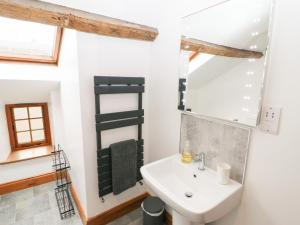 a bathroom with a sink and a mirror at Fryston Cottage in Keswick