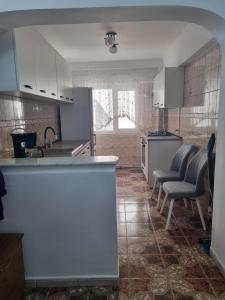 - une cuisine avec un comptoir et des chaises dans la chambre dans l'établissement Apartament Ada, à Gura Humorului
