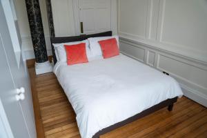 een bed met twee rode kussens erop bij Charrington House in Londen