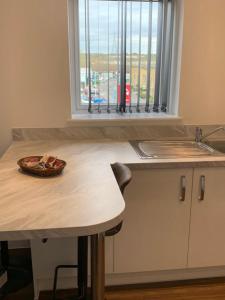 uma cozinha com uma mesa, um lavatório e uma janela em Lakeside 2 BED LUXURY APARTMENT No PARTIES No EVENTS Early Check-in Late Check- Out Allowed em West Thurrock