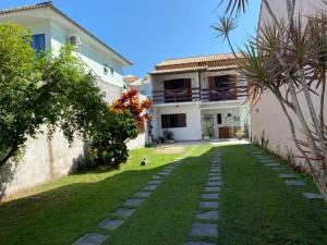 a house with a lawn in front of it at Pousada do Foguete in Cabo Frio