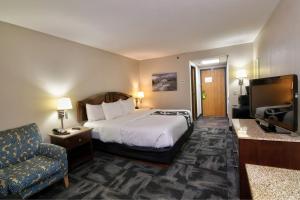 a hotel room with a bed and a chair at La Quinta by Wyndham Springfield South in Springfield