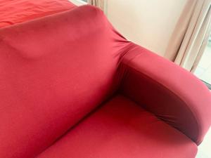 un divano rosso seduto di fronte a una finestra di Couple Red Relaxing Gateway Holiday 10 a Cyberjaya