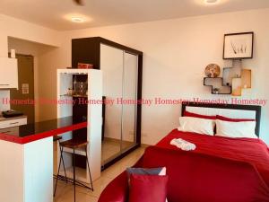 una camera da letto con un letto rosso e uno specchio di Couple Red Relaxing Gateway Holiday 10 a Cyberjaya