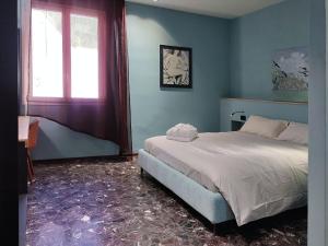 niebieska sypialnia z łóżkiem i oknem w obiekcie Locanda dell'Orsa w Bolonii