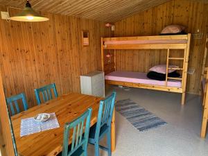 um quarto em madeira com uma mesa e um beliche em Hästveda Vandrarhem och Stugor em Hästveda