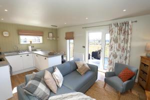 ein Wohnzimmer mit einem blauen Sofa und einer Küche in der Unterkunft The Swift in Whitchurch