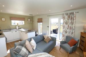 a living room with a blue couch and a kitchen at The Swift in Whitchurch