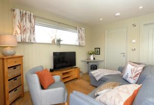 uma sala de estar com duas cadeiras e uma televisão em The Swift em Whitchurch