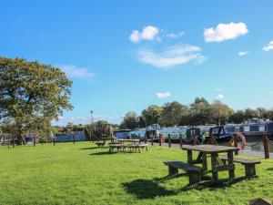 a group of picnic tables in a park with boats at The Swift in Whitchurch