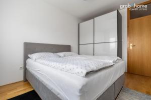a bedroom with a large bed with white sheets at Crosspoint Zagreb in Zagreb