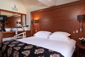 费拉Theoxenia Caldera Hotel的卧室里有一张带木质床头板的白色大床