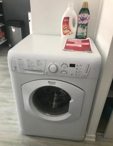 a white washing machine with a bottle of detergent at Charmant Studio in Talence