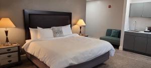 um quarto de hotel com uma cama e uma cadeira verde em Hotel Phillips em Bartlesville