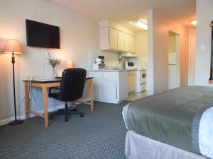 a hotel room with a bed and a desk with a computer at Beausejour Hotel Apartments/Hotel Dorval in Dorval