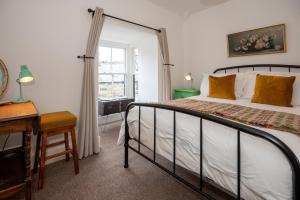 a bedroom with a bed and a desk and a window at Cottage in heart of Dolgellau with parking in Dolgellau