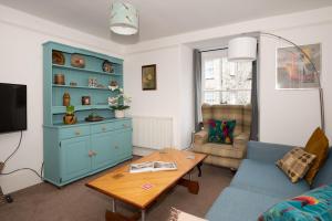 a living room with a blue cabinet and a table at Cottage in heart of Dolgellau with parking in Dolgellau