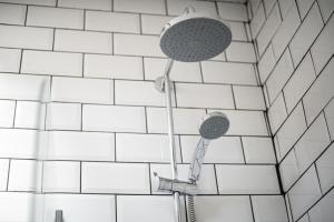 a shower in a bathroom with white tiles at Cottage in heart of Dolgellau with parking in Dolgellau +17 photos