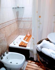 a bathroom with a tub and a toilet and a sink at Jardin Secreto in Rosario