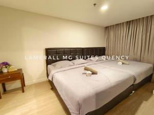 een slaapkamer met een bed met twee kaarsen erop bij Lamerall MG Suites Quency in Semarang