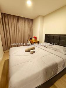 een groot wit bed in een kamer met een tafel bij Lamerall MG Suites Quency in Semarang