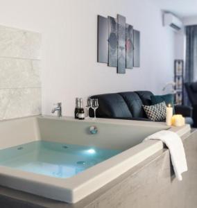 a bathroom with a bath tub with blue water at Dream Suite near Metro Station! in Thessaloniki