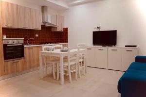 a kitchen with a table and chairs and a tv at Zaras in Lacco Ameno