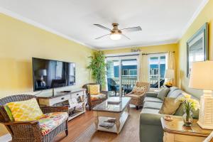 a living room with a couch and a tv at Oceanside 306-B in Isle of Palms