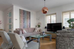 sala de estar con sofá y TV en Appartement Volendam, en Volendam