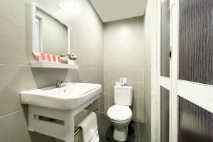 a white bathroom with a sink and a toilet at OYO 90334 Mawlaya Hotel in Bayan Lepas