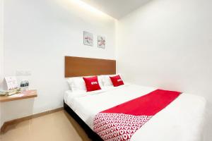 a bedroom with a bed with red and white pillows at OYO 90334 Mawlaya Hotel in Bayan Lepas