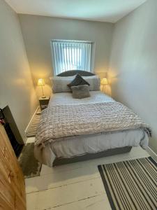 a bedroom with a large bed with two lamps at Number 8 Clandown in Radstock