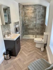 a bathroom with a shower and a sink and a toilet at Number 8 Clandown in Radstock