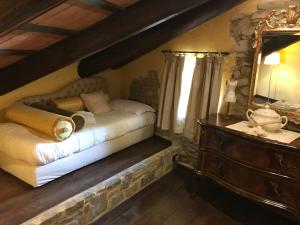 een slaapkamer met een bed, een spiegel en een dressoir bij Dimora I Manichei in Monforte dʼAlba