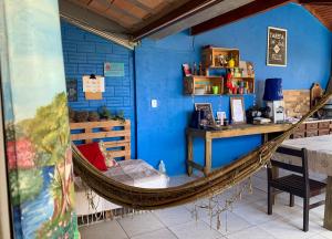 a hammock in a room with a blue wall at Pousada Vilamar in Imbituba
