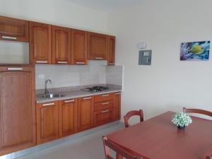 een keuken met houten kasten en een houten tafel bij CoralK Apartments Sosúa in Sosúa