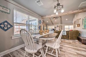 a dining room with a table and white chairs at Lakefront Fort Towson Home with Private Dock! in Fort Towson