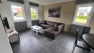 a living room with a couch and a table at Gîte au 14 - au calme avec jardin , proche de Dinant in Anhée