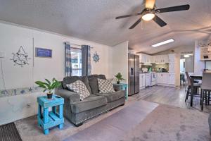 a living room with a couch and a kitchen at Houghton Lake Area Home with Fire Pit and Yard! in Houghton Lake