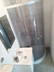 a bathroom with a shower and a sink at Apartamenty Konik Morski Ostrowo in Ostrowo