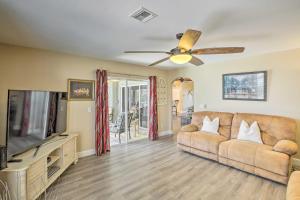 a living room with a couch and a flat screen tv at Stunning Cape Coral Getaway with Lanai and Heated Pool in Cape Coral