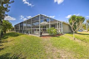 a glass house with a lawn in front of it at Stunning Cape Coral Getaway with Lanai and Heated Pool in Cape Coral