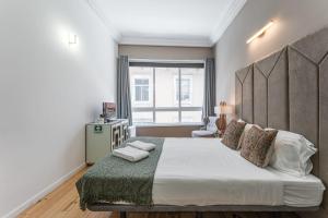 a bedroom with a large bed and a window at GuestReady - Gold Leaf 2F in Porto