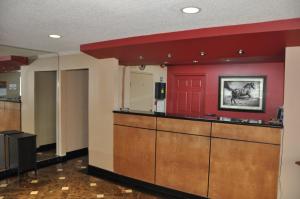 a lobby with red walls and a kitchen with a counter at Heritage Inn in Beaumont