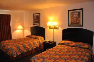 a hotel room with two beds and two lamps at Heritage Inn in Beaumont