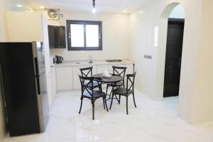 una cucina con tavolo, sedie e frigorifero di Al Khuzama Resort a Taif