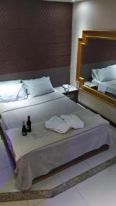 a large bed with two towels and a mirror at Hotel La Costa - Adults Only in Rio de Janeiro